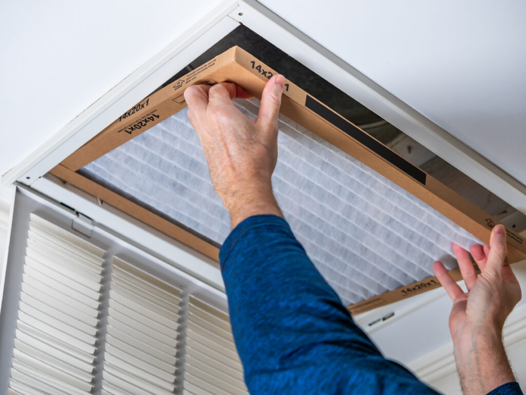 HVAC technician replacing a home air filter in Perris
