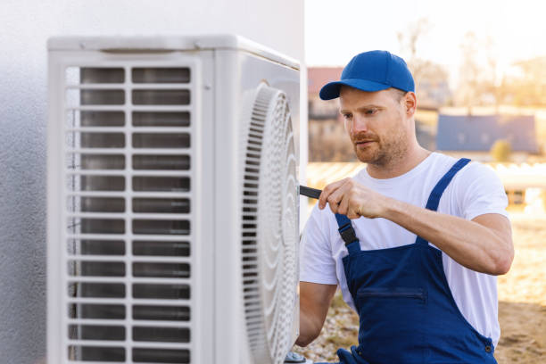 HVAC technician servicing an outdoor air conditioner in Perris