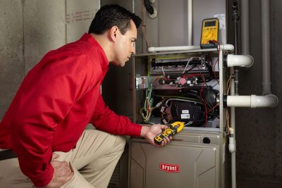 Heating technician diagnosing a furnace repair in Perris