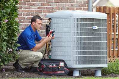 HVAC technician inspecting an outdoor AC unit in Perris